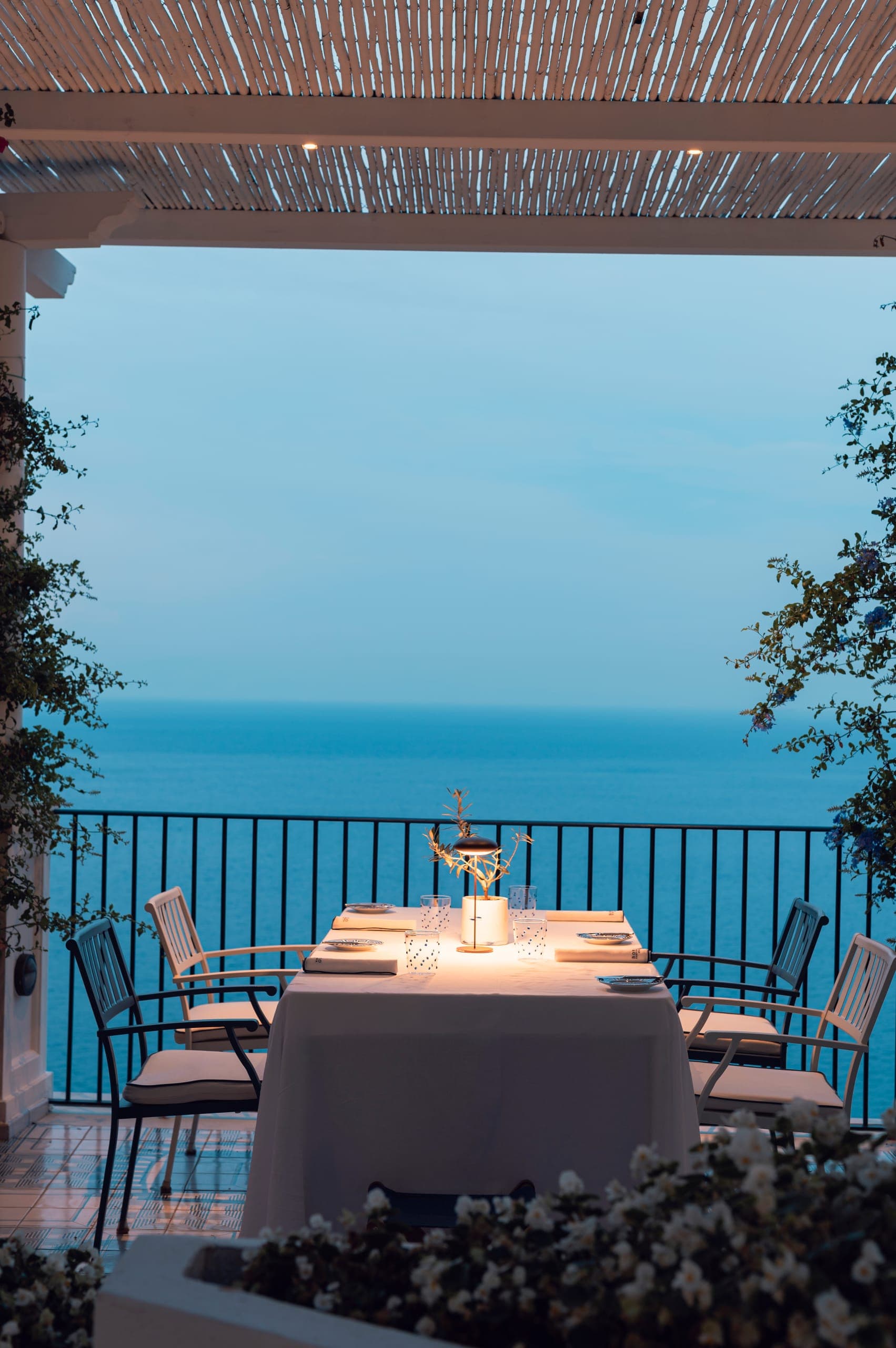 Tavolo apparecchiato sulla terrazza di Alici al tramonto, con vista sul mare